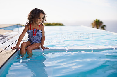 Buy stock photo Shot of a little girl dipping her feet in the pool