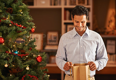 Buy stock photo Cropped shot of a young man opening a christmas present