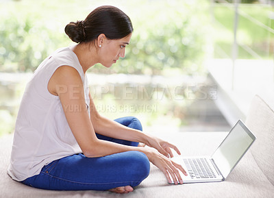 Buy stock photo Laptop, relax and blogging with woman on sofa in living room of home, typing article for publishing. Computer, research and remote work with young writer in apartment to work on story or novel