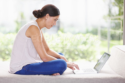 Buy stock photo Profile, laptop and blogging with woman on sofa in living room of home, typing article for content. Computer, email and remote work with young freelance employee in apartment for research or info