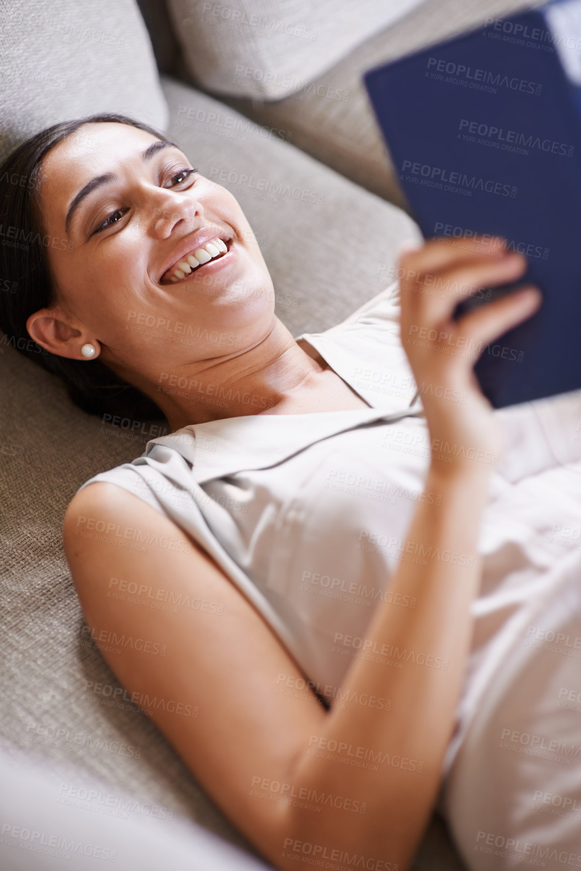 Buy stock photo Woman, smile and relax on sofa with book, reading and learning with story and literature entertainment at home. Happy, female person in living room with fiction or comedy novel on couch for leisure