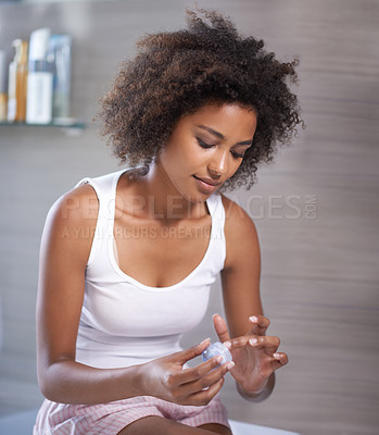 Buy stock photo African woman, cream and container in morning, skincare or start routine in bathroom at apartment. Girl, person and serum for change, cosmetics or benefits for facial skin with transformation in home