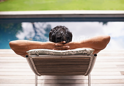 Buy stock photo Rearview shot of a young man lying by a pool