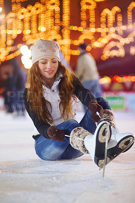 Buy stock photo Ice skating, happy and woman tie shoes on rink to start fitness, exercise and workout at night. Skater, smile and female person tying skate laces for winter training, preparing and getting ready.