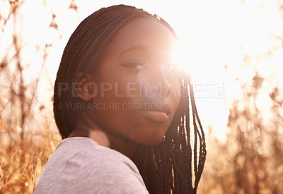 Buy stock photo Portrait of an attractive teenage girl in a field with the sun behind her