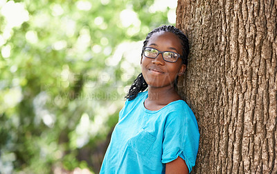 Buy stock photo Shot of a pretty teenage girl leaning against a tree