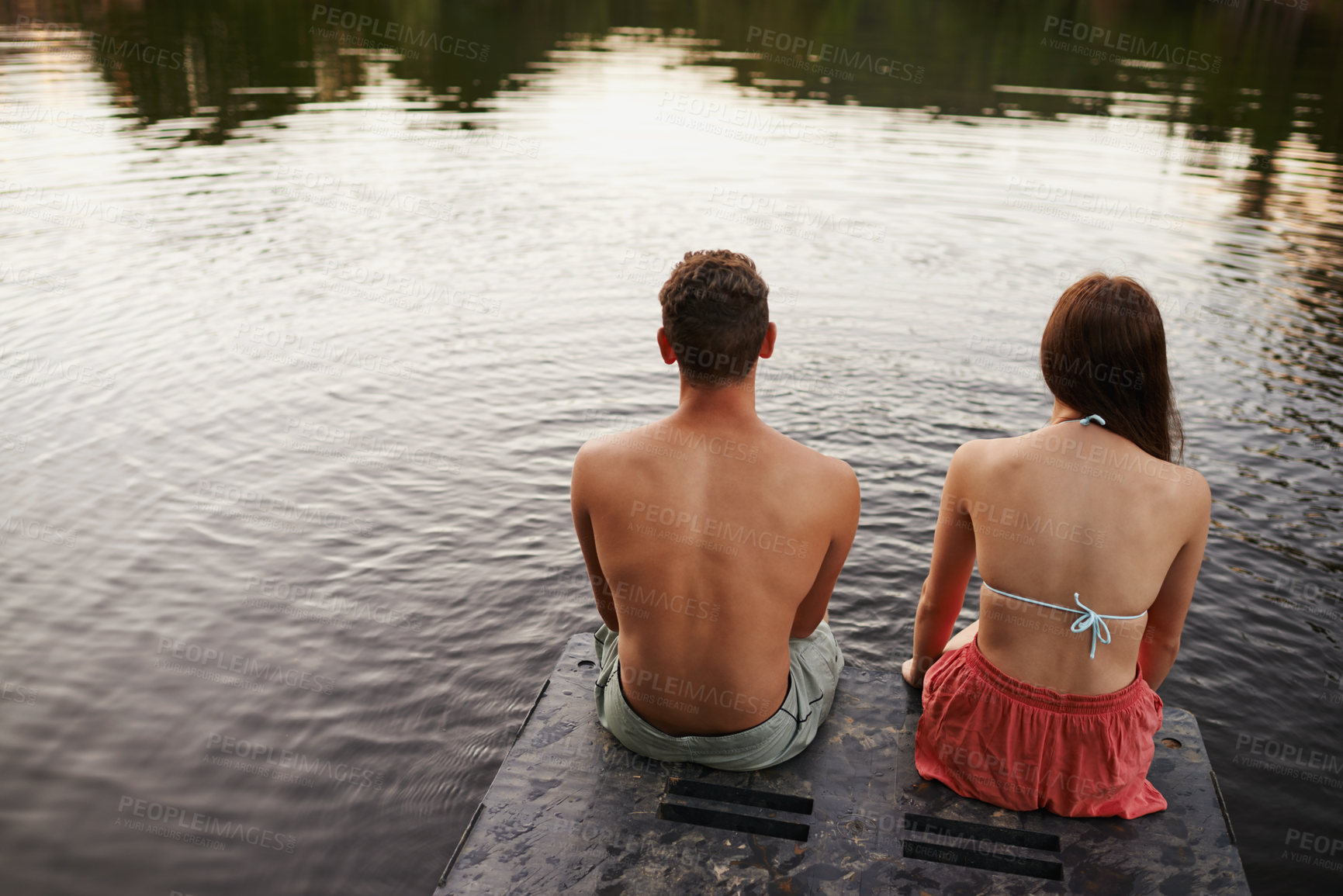 Buy stock photo Relax, water and couple on pier at lake together for holiday adventure in nature from back. Vacation, young woman and man with calm morning, reflection and outdoor countryside on dock with river view