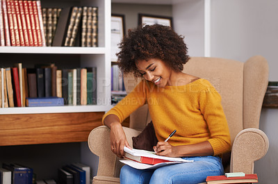 Buy stock photo Cropped shot of an attractive young woman studying on her sofa