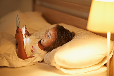 Buy stock photo Girl, child and tablet in bed at night, comfortable and online for games or playing in home. Female person, kid and resting in bedroom or lying to relax, website and internet or app for entertainment