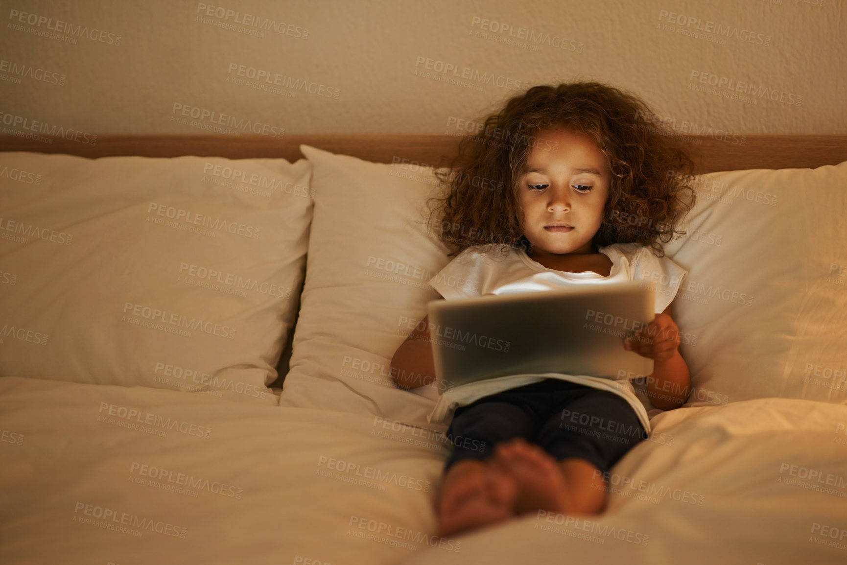 Buy stock photo Streaming, child and tablet in bed at night, comfortable and online for games or playing in home. Female person, girl and reading in bedroom to relax, website and internet or app for entertainment
