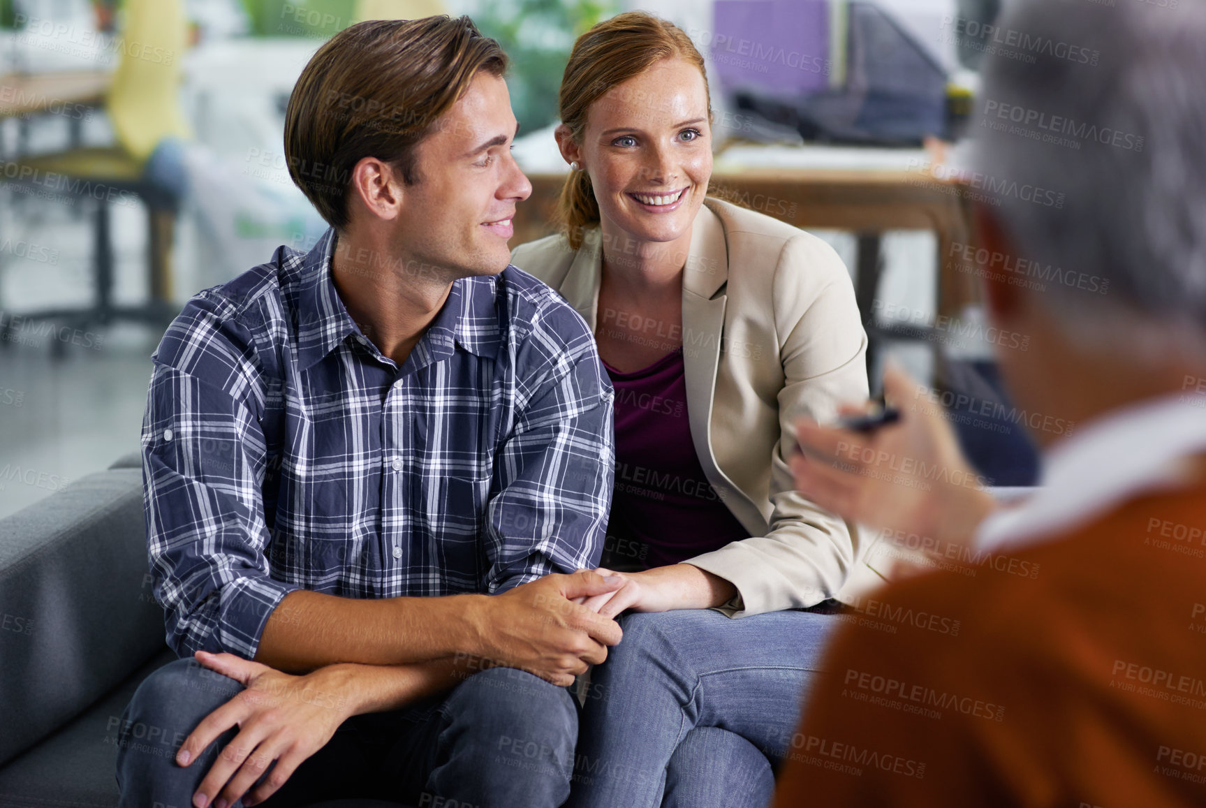 Buy stock photo Marriage, therapy and couple with smile for advice in communication with partner, together and couch. Consulting, man and woman holding hands, conversation and psychologist in office for counselling
