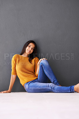 Buy stock photo Portrait, woman and style on floor for leisure with casual outfit for fashion or comfort, relax and wellness with smile. Female person, isolated with grey background or wall for clothing with mockup.