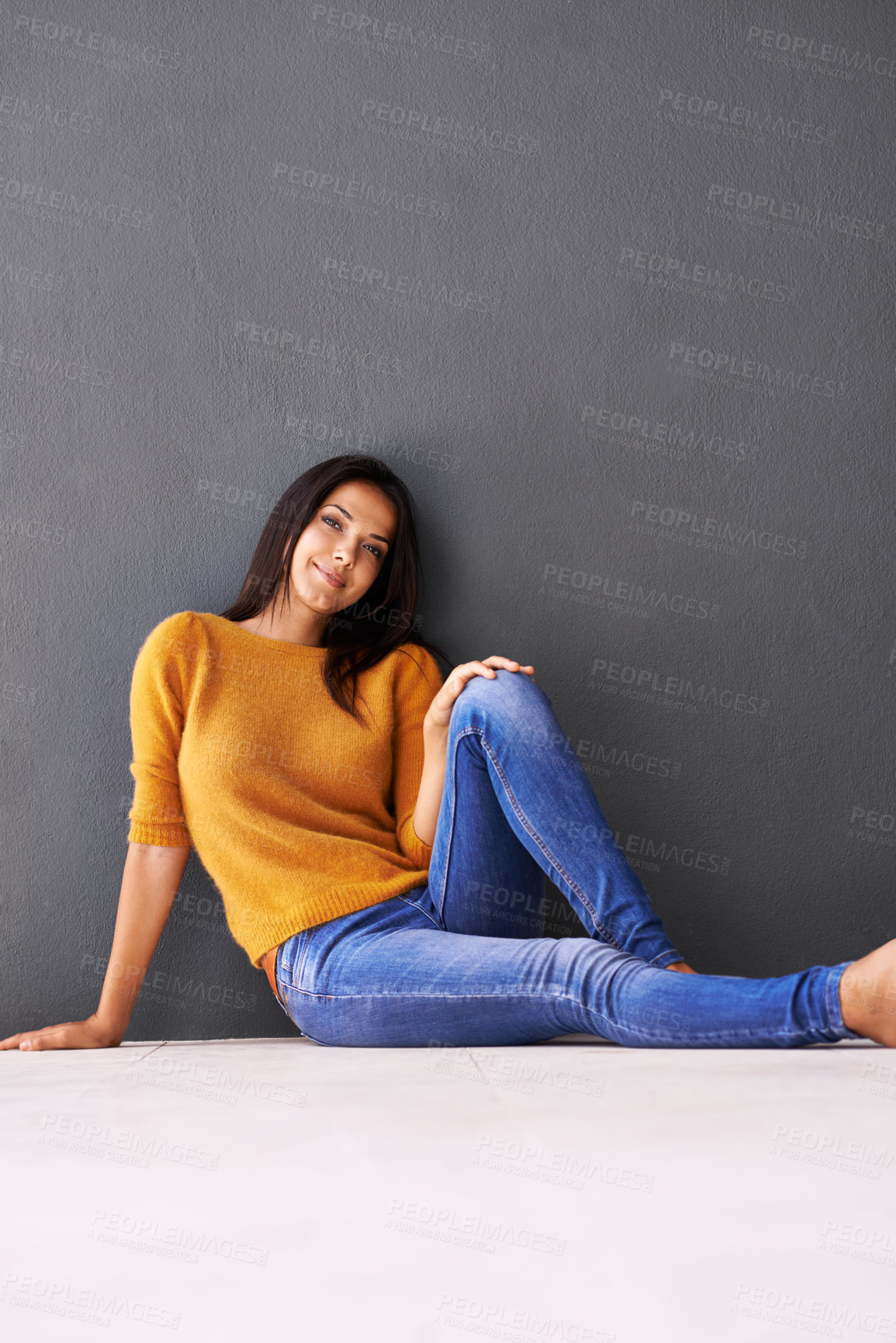 Buy stock photo Portrait, woman and style on floor for leisure with casual outfit for fashion or comfort, relax and wellness with smile. Female person, isolated with grey background or wall for clothing with mockup.