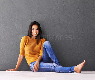 Buy stock photo Portrait, woman and sit on floor for comfort with casual outfit or fashion to relax, leisure and wellness with luxury. Female person, isolated with grey background or wall for clothing with mockup