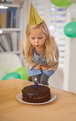 Buy stock photo Child, birthday and blow cake candle in home, celebration for three year old or party wish. Happy girl, dessert on table, excited or cheerful event for growth or special decoration and fun hat