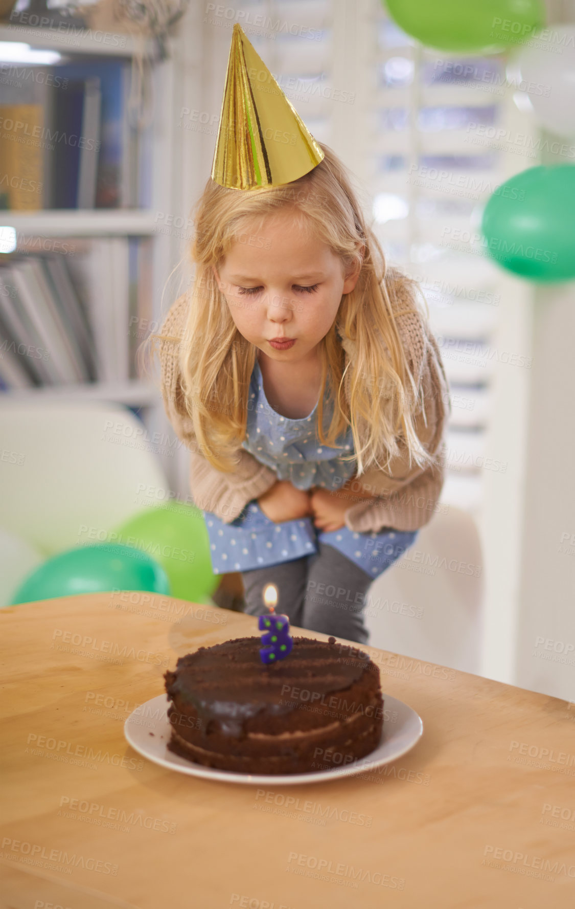 Buy stock photo Child, birthday and blow cake candle in home, celebration for three year old or party wish. Happy girl, dessert on table, excited or cheerful event for growth or special decoration and fun hat