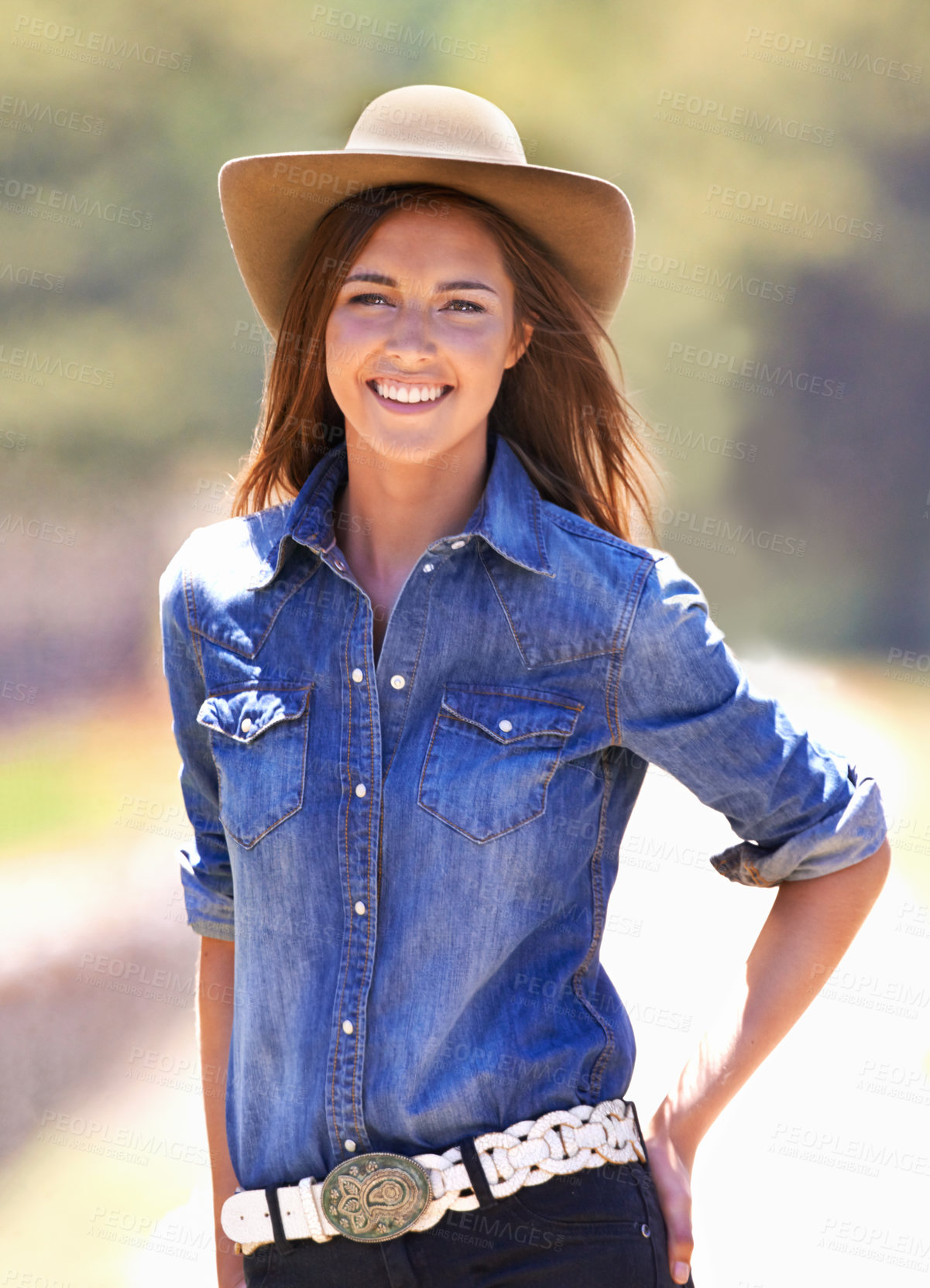 Buy stock photo Happy woman, portrait and cowgirl with hat on farm for adventure, travel or outdoor journey in Texas. Female person with smile in western fashion, denim shirt and cap at ranch in the countryside 