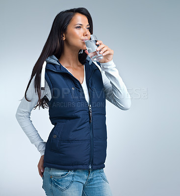 Buy stock photo Woman, drink water for health and hydration in studio, nutrition and wellness with thirst on grey background. Liquid, aqua and mineral with h2o in glass, fresh and clean for refreshment and detox