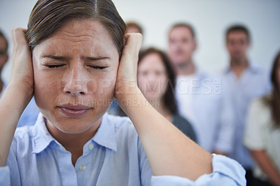 Buy stock photo Shot of a stressed young woman trying to block out the world