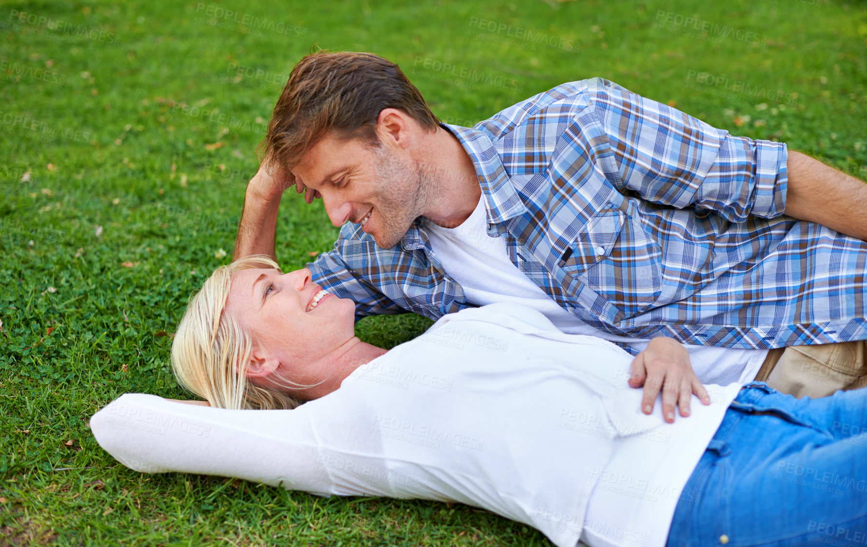 Buy stock photo Couple, relax on grass and bonding in park for love, trust in commitment and marriage. Happy people on date, together outdoor for fresh air and romance with support, loyalty and peace on picnic