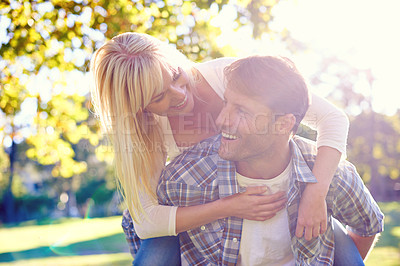 Buy stock photo Couple, smile and park piggyback for love together on vacation or nature explore, sunshine or relax. Man, woman and face for holiday in environment for relationship happiness, summer or adventure