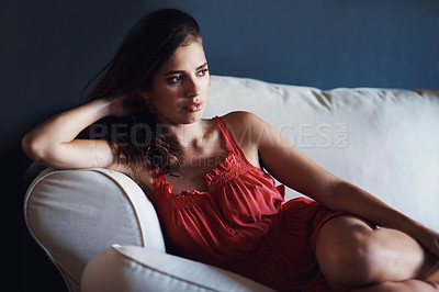 Buy stock photo Relax, fashion and thinking with woman on sofa in studio on blue background for feminine wellness. Idea, future and vision with confident or serious young person in red dress for quiet contemplation