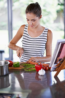 Buy stock photo Food, home and cooking for woman in kitchen with vegetables on counter for health, diet or recipe for dinner. Chef, vegan with knife and salad on board for soup, eating and lunch on menu on meal prep