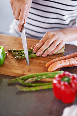 Buy stock photo Cropped shot of a woman chopping vegetables