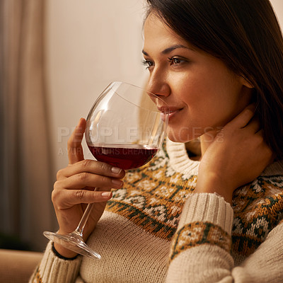 Buy stock photo Cropped shot of an attractive young woman enjoying a glass of wine while relaxing at home