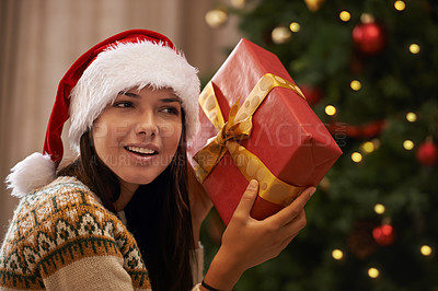 Buy stock photo Christmas, happy and woman with present at her home for festive celebration, event or party. Smile, guess and young female person with gift box for xmas surprise in living room at modern apartment.