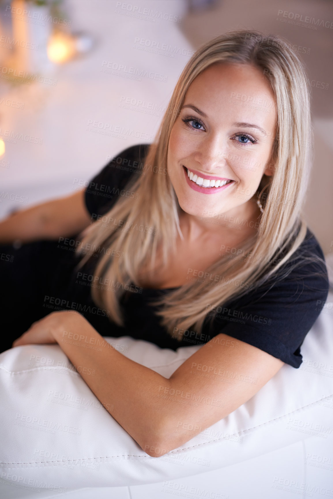 Buy stock photo Portrait of a young blonde woman sitting on her sofa at home