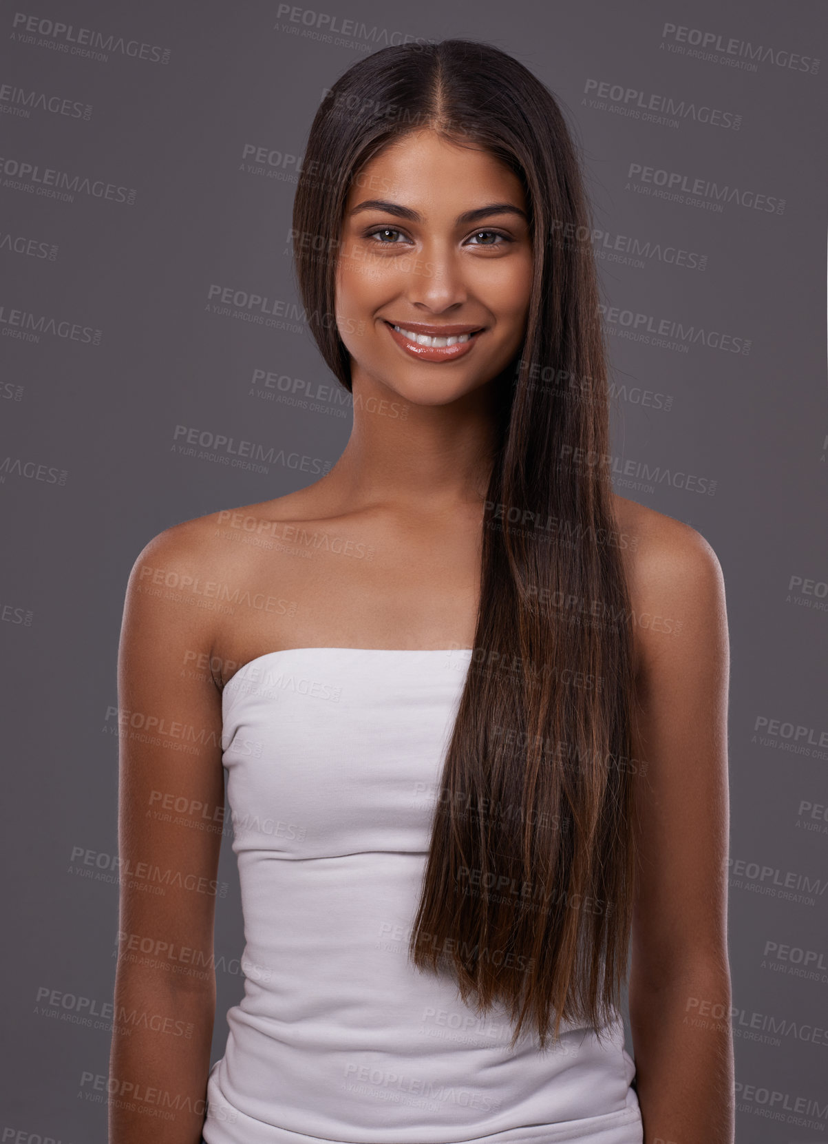 Buy stock photo Hair care, portrait and happy woman with beauty or skincare isolated on gray studio background. Hairstyle, cosmetics and face of Indian model in makeup at salon for glow, shine or body at hairdresser