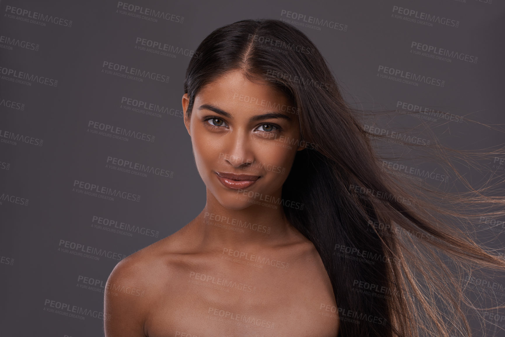 Buy stock photo Hair care, wind and portrait of woman with beauty, shine or skincare isolated on a gray studio background. Hairstyle, cosmetics and face of Indian model in salon with makeup at hairdresser for glow