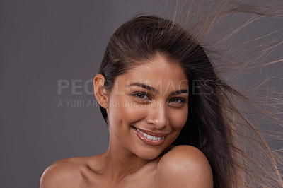 Buy stock photo Hair, wind and portrait of happy woman in makeup for beauty or shine isolated on a gray studio background. Hairstyle, skincare and face of Indian model in salon with cosmetics at hairdresser for care