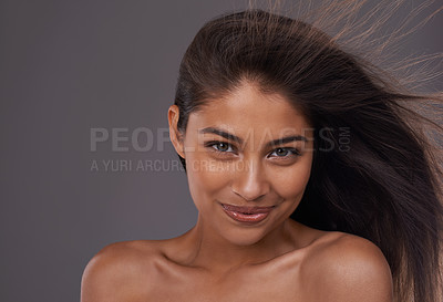 Buy stock photo Hair, wind and portrait of happy woman for skincare, beauty or shine isolated on a gray studio background. Hairstyle, cosmetics and face of Indian model in salon with makeup at hairdresser for care
