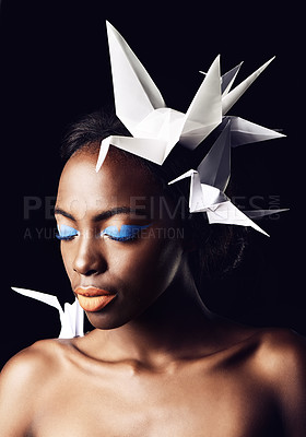 Buy stock photo Black woman, fine art and blue eyeshadow with beauty, dove or origami birds on a dark studio background. Closeup or face of African female person or model with makeup or cosmetics on mockup space