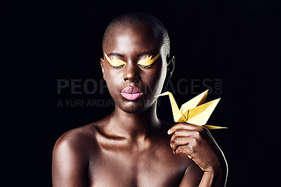 Buy stock photo Cropped shot of a beautiful ethnic woman posing with her eyes shut while holding an origami bird