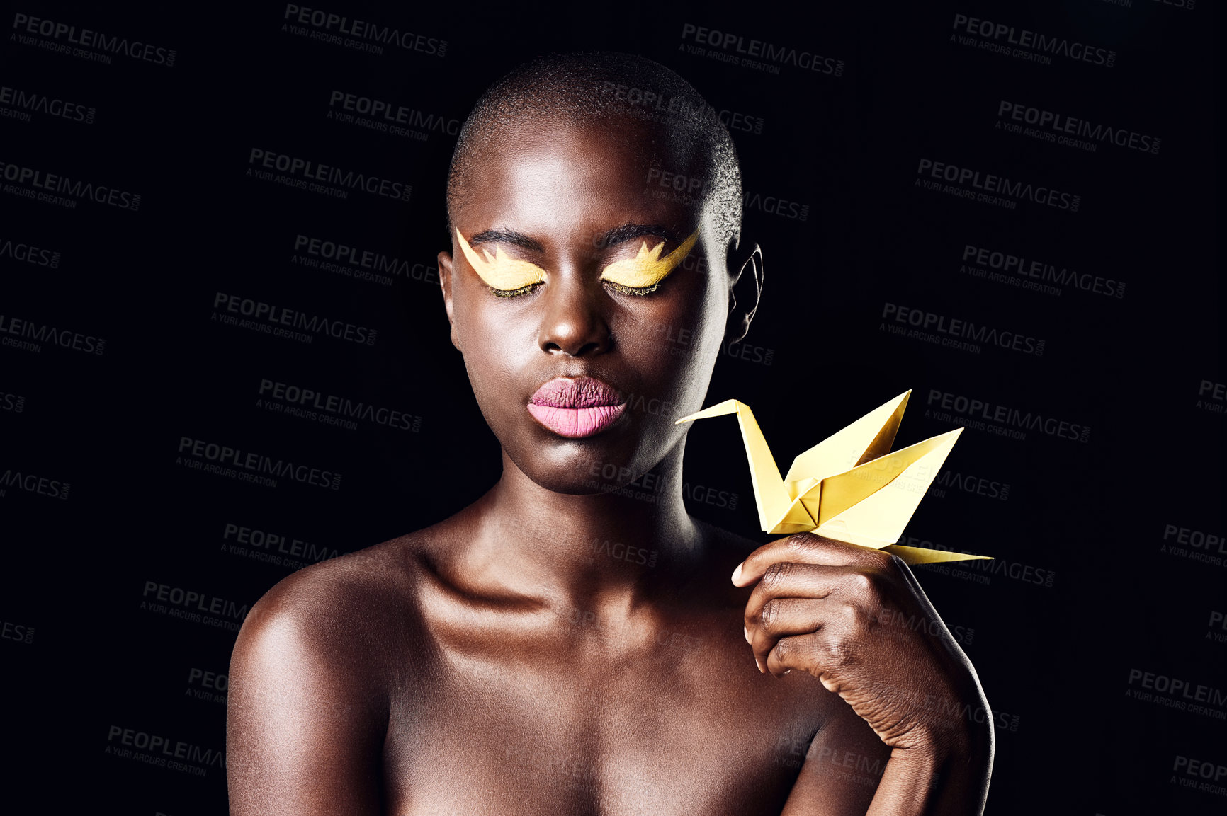 Buy stock photo Cropped shot of a beautiful ethnic woman posing with her eyes shut while holding an origami bird