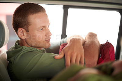 Buy stock photo A thoughtful man sitting in the back of a car holding a bag