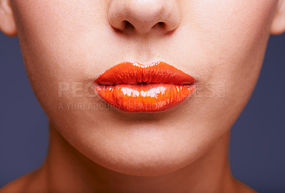 Buy stock photo Cropped shot of a woman's lips covered in shiny orange lipstick