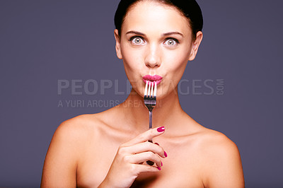 Buy stock photo Portrait of a beautiful young woman biting on a fork