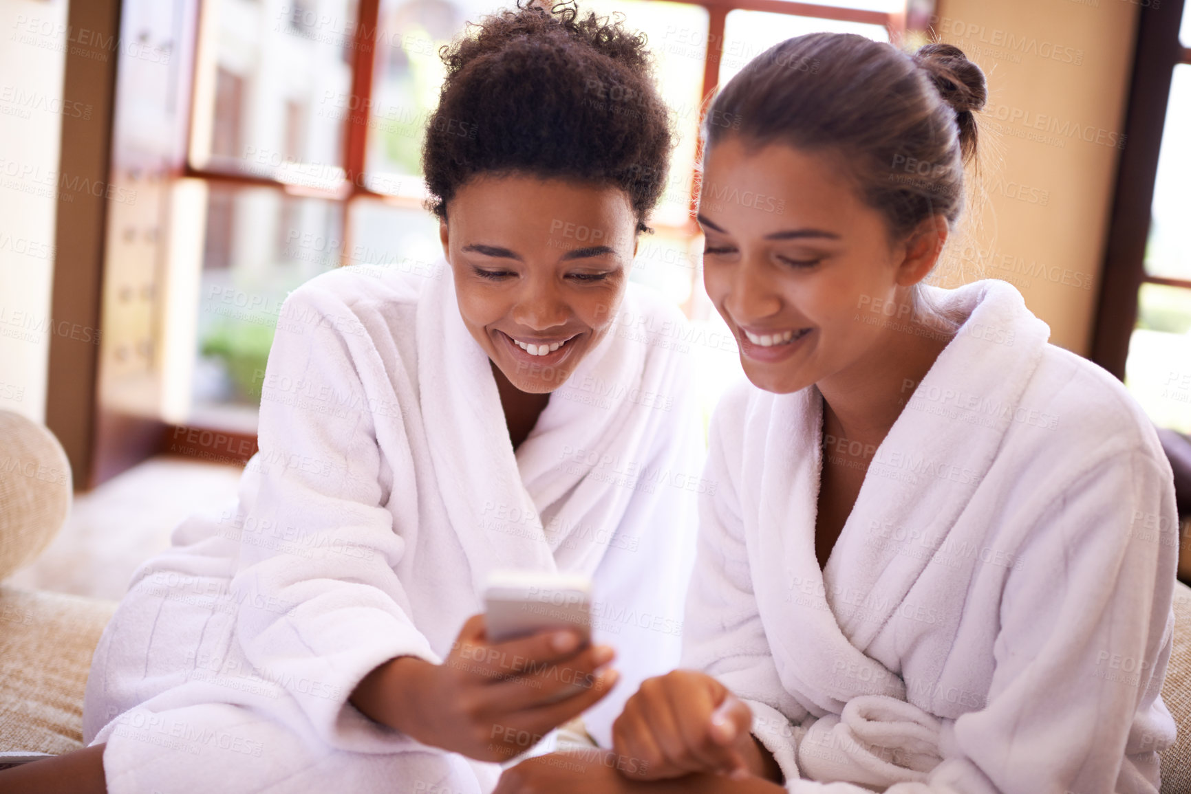 Buy stock photo Beauty, phone and spa with woman friends in robes for luxury pampering or treatment together. Smile, app and social media with happy young people at resort or salon for wellness or weekend getaway