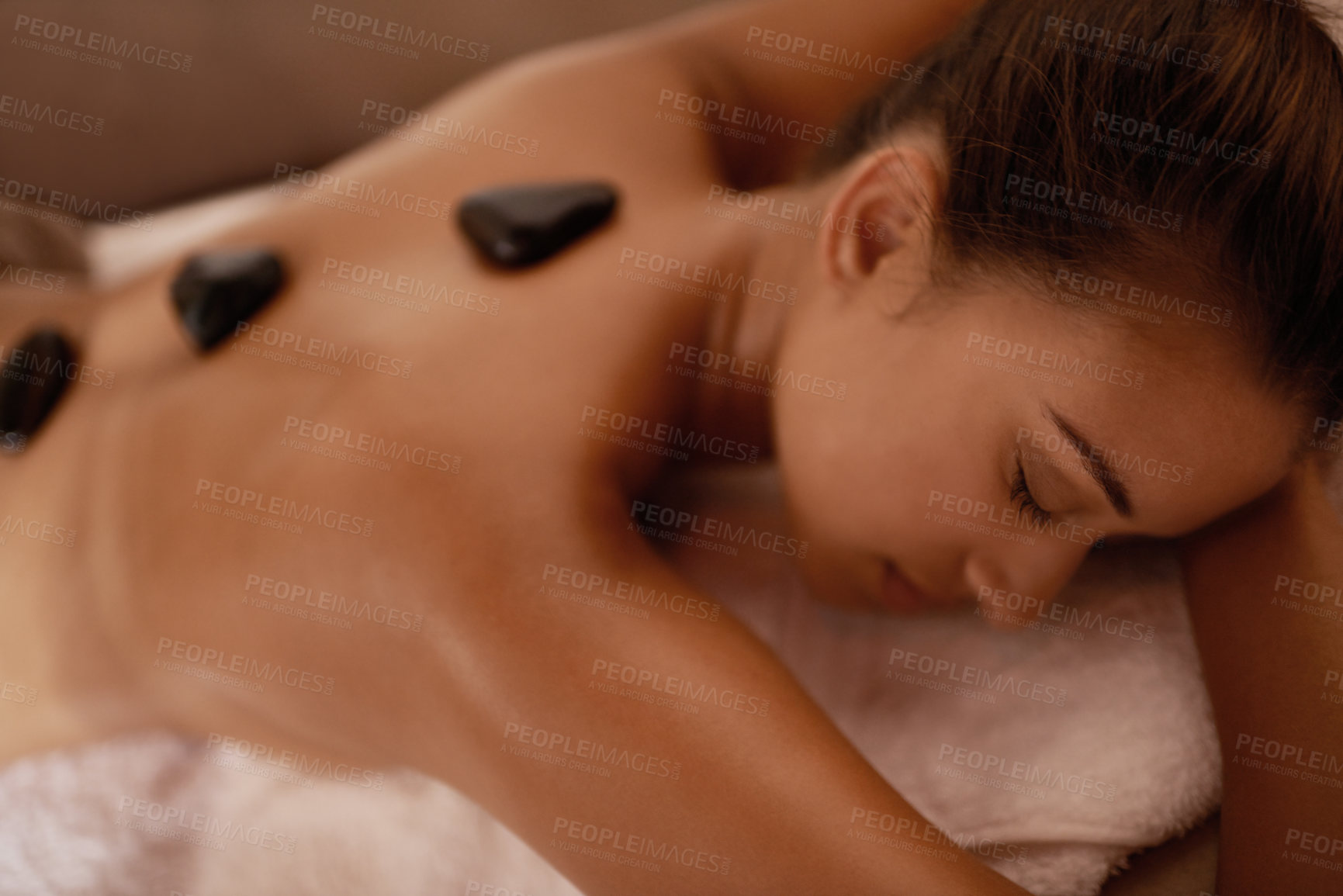 Buy stock photo Back, hot stone massage and woman in bed with luxury service for muscle, body and relax with peace in resort. Girl, hospitality and physical therapy for spine with wellness, spa and natural healing