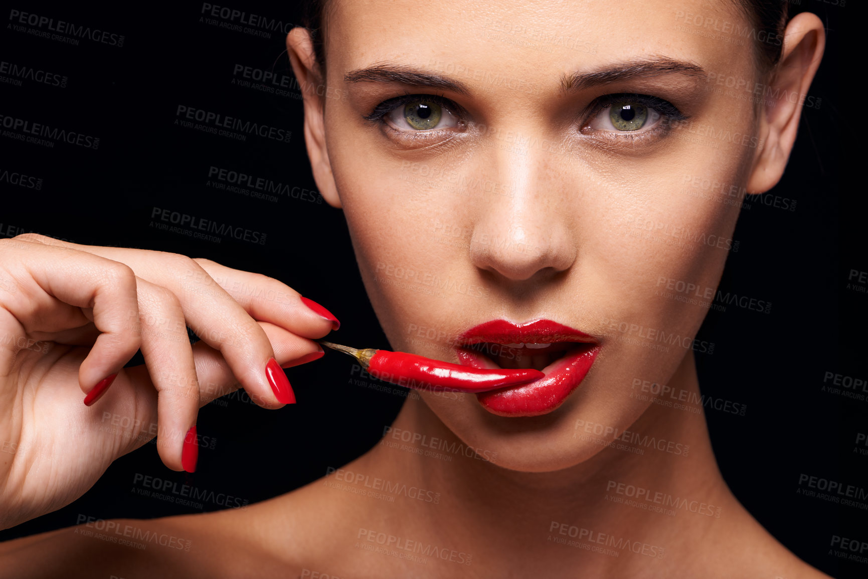 Buy stock photo Beauty, portrait and woman with a chilli in a studio for a sensual, glamour and sexy aesthetic. Cosmetic, makeup and female model with a pepper with red lipstick isolated by a dark black background.