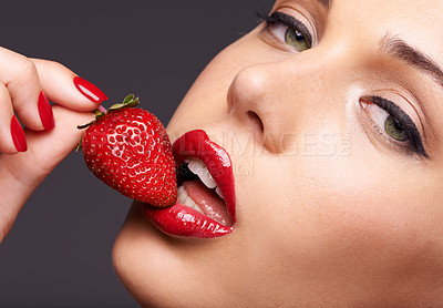 Buy stock photo Beauty, portrait and model with a strawberry in studio with red nails and lipstick cosmetics. Health, wellness and closeup of woman with makeup eating fruit for nutrition isolated by gray background.