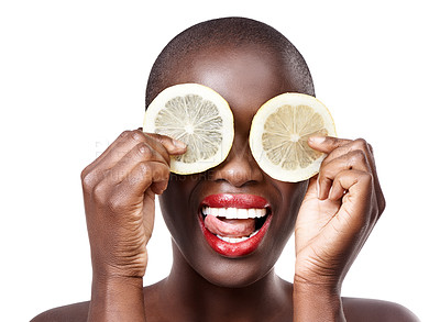 Buy stock photo Studio shot of a beautiful model holding lemon slices up to her eyes