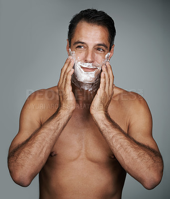 Buy stock photo Man, shaving and foam for beard skincare or after shave with hair removal product, transformation or grey background. Male person, hands and studio wellness or face application, grooming or mockup