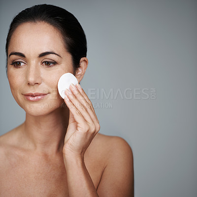 Buy stock photo Mature woman, pad and hygiene in studio, skin care and facial treatment on gray background. Female person, cotton and swab for grooming in daily routine, mockup space and dermatology to remove makeup
