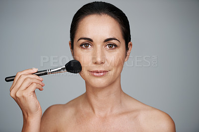 Buy stock photo Beauty, brush and portrait of woman in studio with makeup, natural and facial glow routine. Cosmetics, self care and confident mature female person with cosmetology tool isolated by gray background.