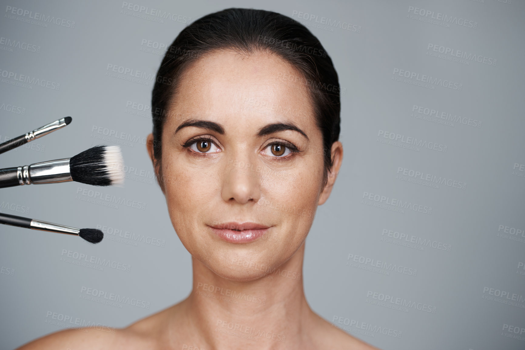 Buy stock photo Makeup, brushes and portrait of woman in studio with beauty, natural and facial glow routine. Cosmetics, self care and mature female person with cosmetology tools isolated by gray background.